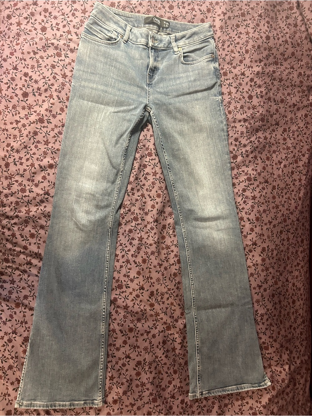 Low rise boot cut light wash flared jeans with a slits in the leg